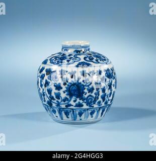 . Small pot of porcelain with a spherical body and narrow, short neck, painted in underglaze blue. On the abdomen a wide bond with continuous flower drinks; around the foot a bond with stylized lotus leaves; On the shoulder Lambrequins with lotus flowers, a half flower in between. Pot has been broken. Ming porcelain in blue and white. Stock Photo