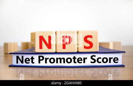 NPS net promoter score symbol. Wooden cubes on book with words 'NPS net promoter score'. White background. Business and NPS net promoter score concept Stock Photo