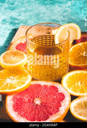 Refreshing summer citrus cocktail drink in a glass at the swimming pool. Oranges, lemons, grapefruits with cold sweet and sour tonic, vodka or aperol Stock Photo