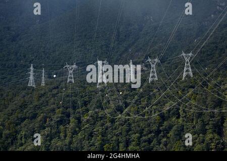 Power lines from Manapouri Power Station, and native forest, Lake Manapouri, Fiordland National Park, South Island, New Zealand Stock Photo