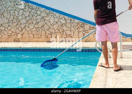 Man cleaning the pool with a net Stock Photo