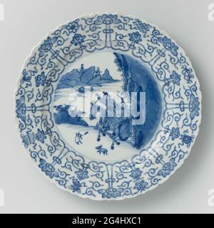 . Dish of porcelain with round, ribbed wall and scalloped edge, painted in underglaze blue. On the flat a yacht scene with two armed riders in a landscape, jaming on a hare; the edge with a concerted tire from lotus drinks, between the eight lucky symbols (chakra, shell, parasol, canopy, lotus, vase, fish, infinite knot); The back with sixteen loose flower branches. Marked on the underside with the six character mark of Emperor Chenghua in a double circle. Edge slightly damaged. Blue White. Stock Photo