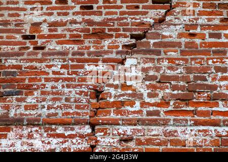 Old red brick wall with a large crack. Stock Photo