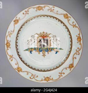 . Porcelain plate, painted on the glaze in blue, red, pink, green, black and gold. On the flat the coat of arms of the family of BEVENDINGH. The weapon has shown a black background with a unicorn. The helmet sign is a crown. Two unicorns are shown on the side of the weapon, standing on a base of leafwork. On the wall a Spearhead border and on the edge a European decorative bond with shell motifs and tendrils. Weapon porcelain with email colors. Stock Photo