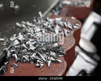 Metal shavings on the surface of lathe, close up. Turned metal particles Stock Photo
