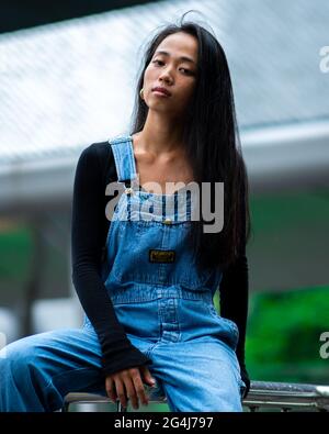 Asian girl in city leans on railings Stock Photo