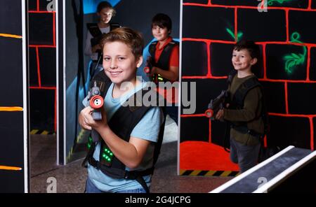 boy aiming laser gun at other players during lasertag game Stock Photo