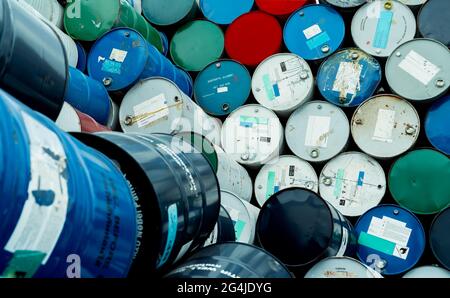 Old chemical barrels. Blue, red, and green chemical drum. Steel tank. Hazard chemical barrel with flammable liquid warning label. Industrial waste. Stock Photo