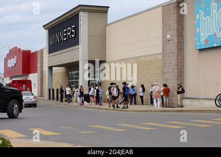 Ottawa, ON, Canada - June 11, 2021: Customers line up at a Winners store on the first day non-essential retailers are permitted to open after lockdown. Stock Photo