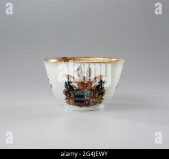 . Bell-shaped head of porcelain, painted on the glaze in blue, red, pink, green, yellow, gardenquoise, black and gold. On the Buitnwand the coat of arms of the families of Reed of Oudtshoorn and Boesses. In the center the weapon whose shield is divided into two. Left The weapon of Van Oudtshoorn Reed in Gray, right the coat of arms of Boesses in red and blue. There is a griffin on either side of the weapon. The helmet mark consists of a crown and wings. On the wall loose flower branches in European style and a decorative band on the inner edge. Weapon porcelain with email colors. Stock Photo