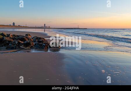 Oostende (Ostend) beach with skyline and pier at sunset with breakwater along North Sea, Flanders, Belgium. Stock Photo