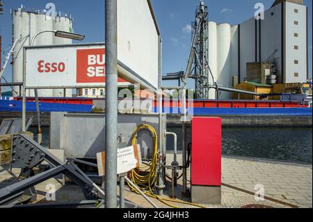 Fehmarn, Germany. 20th June, 2021. The multi-purpose vessel 'Jeanny' is moored in the municipal port of Burgstaaken in front of silos for feed and fertilizer. The harbour basin is to be dredged to a depth of five metres to make the small harbour competitive again. (to dpa 'Fehmarn wants to deepen Burgstaaken municipal harbour') Credit: Gregor Fischer/dpa/Alamy Live News Stock Photo