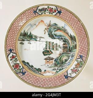 . Deep plate of porcelain, covered with a pink glaze and painted on the glaze in blue, red, pink, green, yellow, purple, black and gold. On the flat a river landscape with a boat, pavilions, trees and mountains; On the wall a band with napkin; The edge with a wide and a narrow band napkin work, the wide interspersed with three cartouches with flower and fruit branches. The rear is covered with a pink glaze. Famille Rose with a Ruby Back. Stock Photo