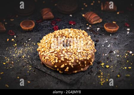 Still life of chocolate donut sprinkled with crunchy peanut Stock Photo