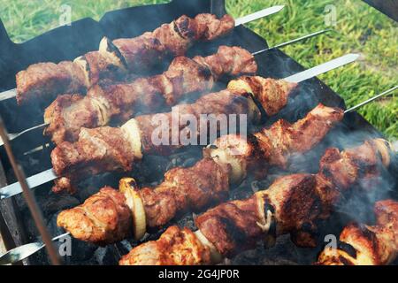 Marinated shashlik preparing on a barbecue grill over charcoal. Shashlik or Shish kebab popular in Eastern Europe. Shashlyk (skewered meat) was origin Stock Photo