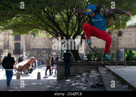 A skater jumps down stairs in a plaza in the middle of International Skate Day in Bogota, Colombia on June 21, 2021 Stock Photo