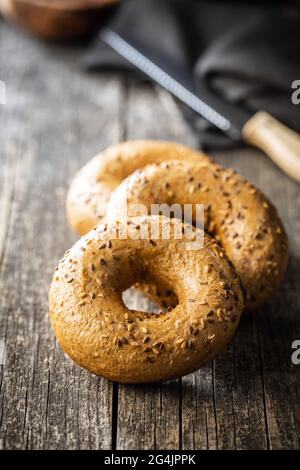 Whole grain baked bagel on wooden table. Stock Photo