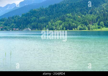 Lake Weissensee in Carinthia and a boat in the distance, horizontal format Stock Photo