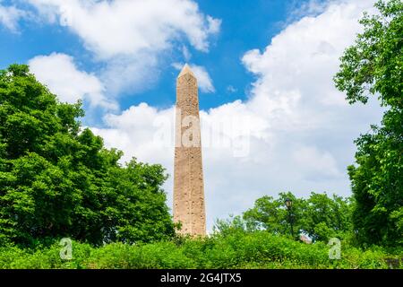 Cleopatra's Needle Egyptian obelisk in Central Park. Green trees. Blue sky - New York, USA - 2021 Stock Photo