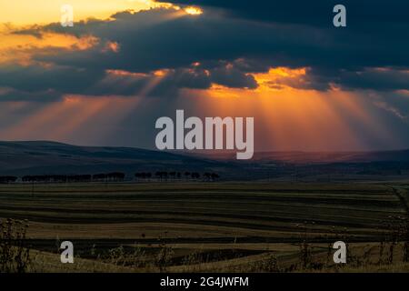 Dramatic sunset over farm fields Stock Photo