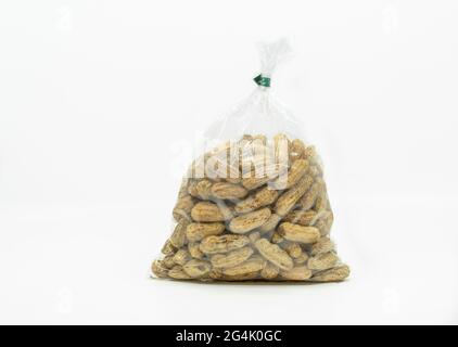 Close up of boiled peanuts in a cleared plastic bag for sale in the market, ready to eat, solated image on white background, front view of the bag. Stock Photo