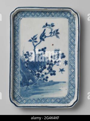 Rectangular Dish With Flowering Plants, A Bird and Insects near A Rock. Shallow, rectangular scale of porcelain with squeezed corners, painted in underglazer blue. On the flat a bird on the branch of a flowering plant (peony) and two butterflies at a rock. This is a bond with napkin. The outer wall with a blue bond with prunus flowers in reserve. The bottom is unglazed. Old label on the bottom with 'legacy Mrs. A.M. Kickhefer / Japan, Arita, 18th century / 1967 '. Arita, blue-white. Stock Photo