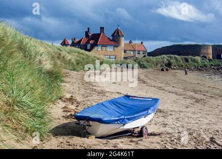Beadnell Harbour, Beadnell, Northumberland, UK; boat with a blue cover on the beach. Stock Photo
