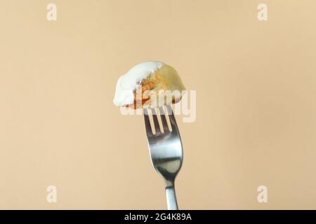 Fork with varenik or pierog on beige background Stock Photo