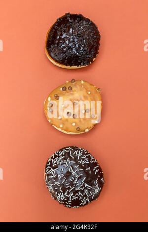 Delicious glazed chocolate donuts on vibrant background Stock Photo