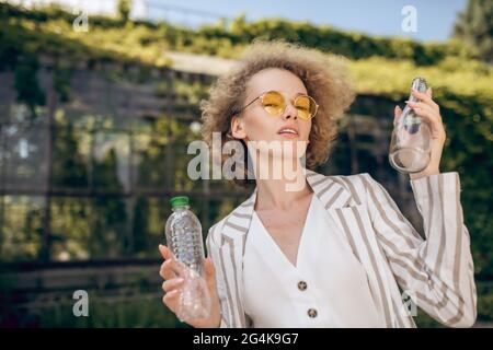 Fair-haired woman holding plastic bottles in hands Stock Photo