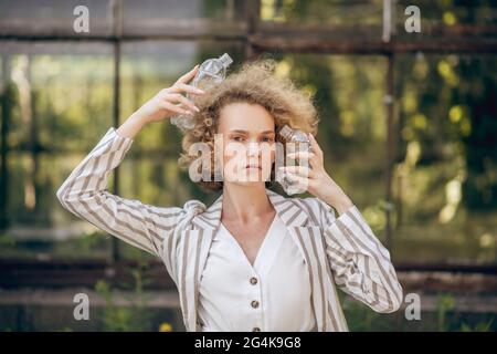 Fair-haired woman holding plastic bottles in hands Stock Photo