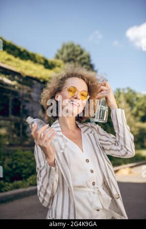 Fair-haired woman holding plastic bottles in hands Stock Photo