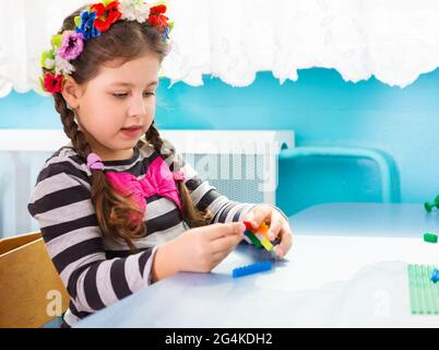 Cute little girl in traditional Ukrainian flower wreath at kindergarten Stock Photo