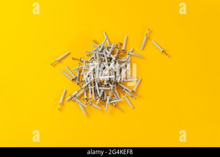 view from above of the bunch of metal steel screws or dowels with plastic caps isolated on table Stock Photo