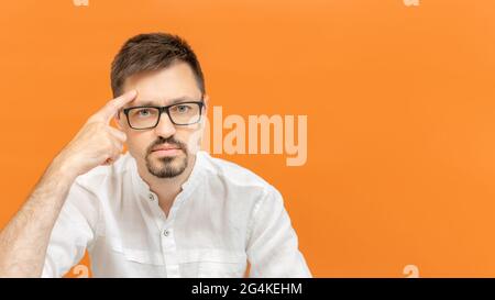 Handsome caucasian man wearing white shirt over isolated background. The young bearded man pointing to head with one finger. Concept of great idea or Stock Photo