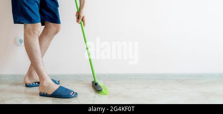 close up person holding a brush and cleaning the floor with a brush at home wide webn banner Stock Photo