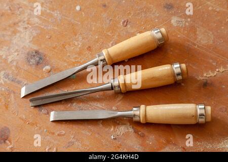 Three Antique Woodworking Chisels Isolated On Wooden Bench Grunge