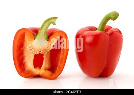 one whole red bell pepper and one cut in half in cross section, isolated on white Stock Photo