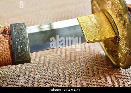 Japanese samurai sword blade or katana on bamboo mat background Stock Photo