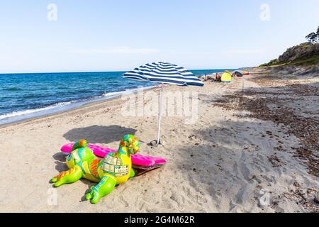 Balloon animal and inflatable mattress on Prunete beach, Corsica, France Stock Photo