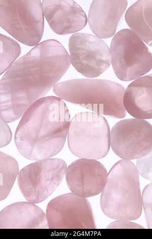Rose quartz jewel heap texture on light surface. Mineral pebbles background. Stock Photo