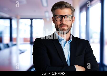 Portrait of handsome businessman wearing shirt and suit while standing at the conference room. Stock Photo