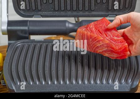 raw tuna steaks cooking on electric grill. Stock Photo