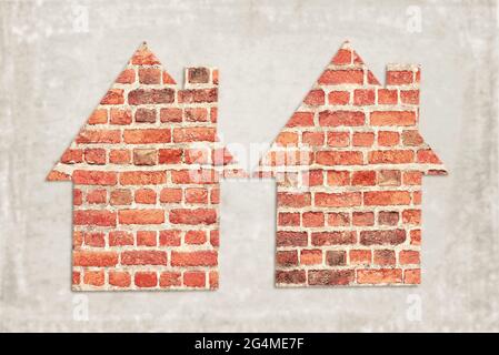 Two houses with brickwork against a grey background Stock Photo
