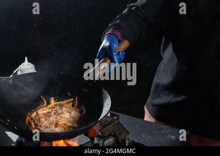 Flambe frying pan wok, cooking on fire. Pan-Asian cuisine. Street food Stock Photo