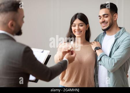 Real Estate Agent Giving Keys To Buyers Stock Photo
