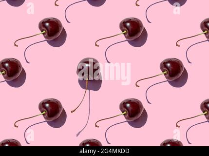 Ripe cherry berries seamless pattern on pink background. Close up. Stock Photo