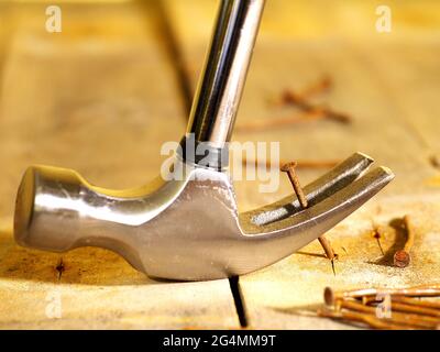 pulling out old rusty nail with carpenter's hammer, shallow depth of field Stock Photo