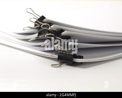 several stacks of paper held by binder clips, shallow depth of field Stock Photo