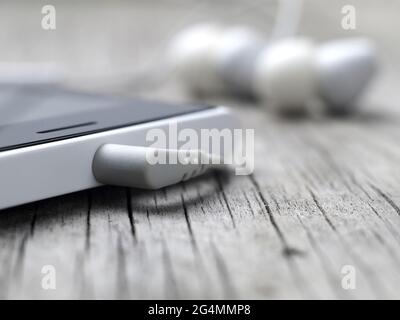 closeup of earphones mini-jack connector on smartphone, macro, shallow depth of field Stock Photo